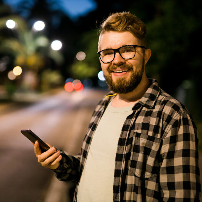 a man holding his phone smiling